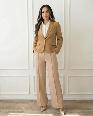 Woman wearing a caramel blazer with beige pants and a white blouse