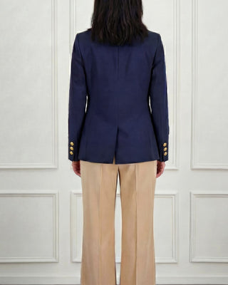 Woman from back wearing a navy blazer and beige trousers