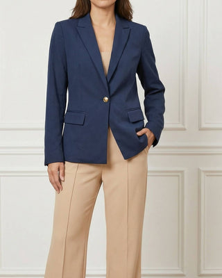 Woman close up wearing a navy blazer with one button in the front and beige trousers